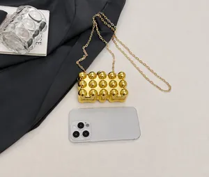 Mini gold acrylic box bag with 3D bubble texture and size comparison to a smartphone