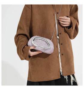 Détail de la pochette en strass roses avec poignée ronde en métal et bandoulière