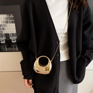 Detail of gold acrylic egg-shaped moon clutch bag with crystal floral accents