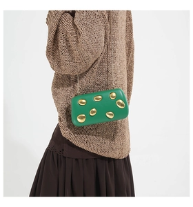 Detail of green PU evening clutch bag featuring elegant gold metallic circular ornaments