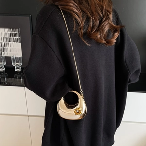 Detail of gold metal crescent evening bag with floral crystal embellishment and chain