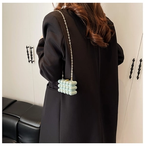 Detail of mint green mini box bag with 3D bubble texture and gold metal chain strap