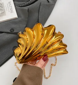 Macro shot of gold shell evening bag with metallic ribbed texture and fine chain strap