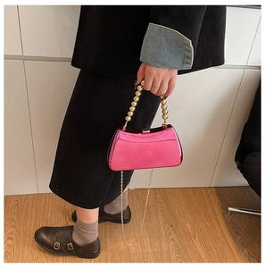 Pink metallic evening bag with gold bead handle and chain strap shown on model