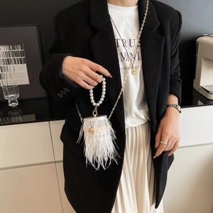 Detail of white ostrich feather evening bag with pearl handle and gold chain strap