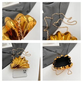 Detail view of gold shell clutch bag showing chain strap and internal storage space