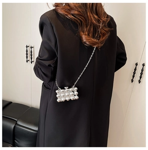 Silver mini chain bag with metallic sphere texture shown on a black suit blazer