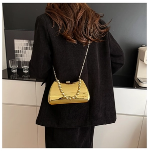 Detailed view of golden mirror acrylic bag with pearl handle and slim chain strap
