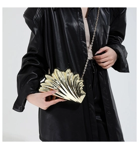 Close-up of golden shell-shaped clutch bag with metallic finish and fine chain strap