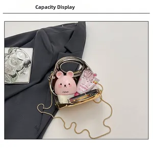 Capacity display of a clear acrylic clutch bag with gold frame and chain strap