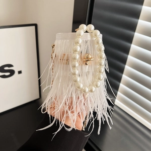 Detailed close-up of fluffy ostrich feathers and white pearl chain handle on a formal bag