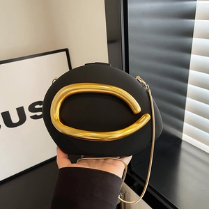 Modern black oval hard shell clutch bag with gold metal ring and sleek snake chain