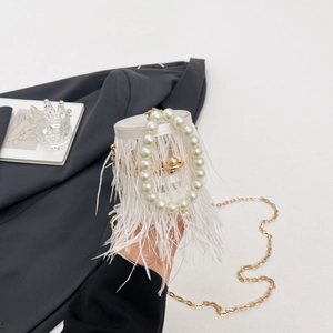 White ostrich feather bucket bag with large pearl handle and gold chain strap