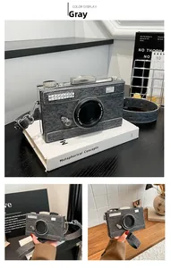 Detail der grauen Denim-Kameratasche mit silbernen Metallakzenten und breitem Tragegurt