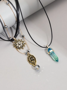 Detail of layered bohemian necklaces featuring a blue crystal pendant and star charms