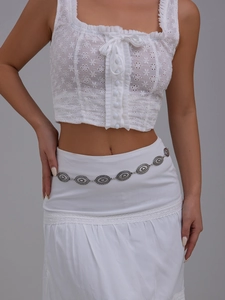 Detail of vintage bohemian silver waist chain with embossed oval links on white dress