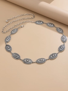 Detail of vintage silver waist chain with oval embossed metal sunburst pattern discs