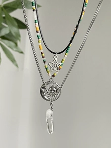 Close-up of bohemian layered necklace set with celestial sun pendant and crystal stone