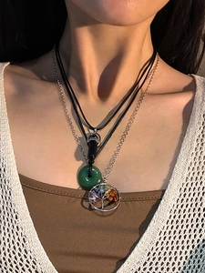 Detail of layered bohemian necklace with crystal point and tree of life stone pendant
