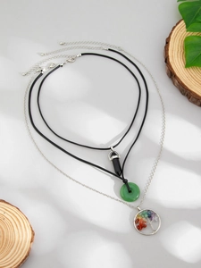 Detail view of multi-layered bohemian necklaces featuring tree of life and crystal pendants