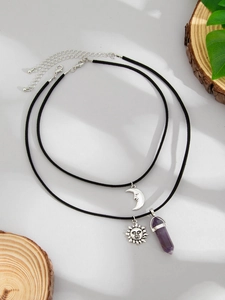 Detail of bohemian layered necklace with silver sun, moon charms and purple crystal stone