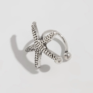 Macro detail of starfish ear cuff with vintage texture and silver-tone finish