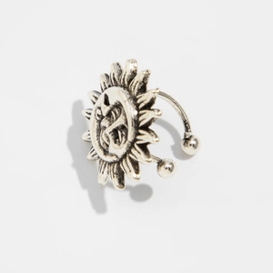 Macro detail of vintage silver starfish ear cuff with smiling sun face relief texture