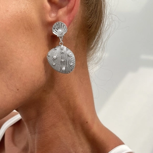 Elegant silver sea shell drop earrings with white pearls on model for summer fashion