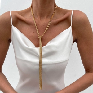 Three-layer gold tassel necklace with mesh chains and decorative knot on model