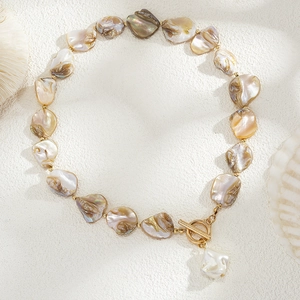 Close-up of Baroque pearl shell necklace with golden toggle clasp and starfish details