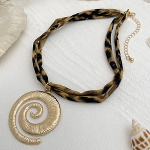 Detailaufnahme des großen goldenen Spiralanhängers mit doppeltem Leopardenmuster-Stoffhalsband
