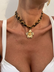 Nahaufnahme eines Chokers mit Leopardenmuster und goldfarbenem 3D-Blumenanhänger am Model