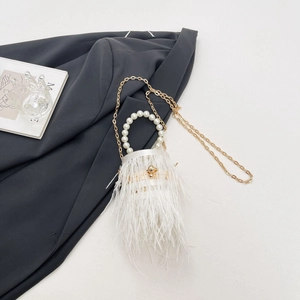 Detail of white ostrich feather evening bag with pearl handle and gold chain strap