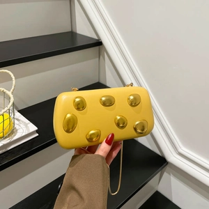 Elegant bright yellow hard shell clutch bag with gold metallic stone accents and chain strap