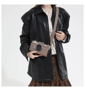 Nahaufnahme einer braunen Tweed-Kameratasche im Retro-Stil mit dekorativen Objektivdetails