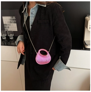 Chic metallic pink pleated acrylic handbag with gold chain strap on stylish model outfit