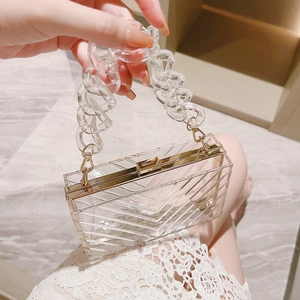 Transparent acrylic evening clutch with V-pattern embossing and gold chain strap
