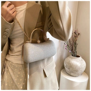 Detail of silver glitter evening clutch with gold handle and sparkling rhinestone clasp