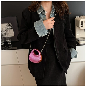 Neon pink acrylic handbag with vertical ridges, gold chain strap, and round hollow handle