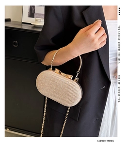 Macro shot of champagne gold evening clutch with sequins and bow-shaped metal clasp