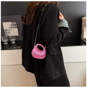 Back view of model wearing a pink crescent acrylic evening bag with gold chain strap