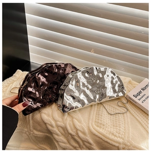 Detail of metallic acrylic clutch bags with ripple texture and delicate metal chain straps