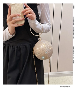 Détail du sac de soirée sphérique doré avec strass scintillants et poignée en métal