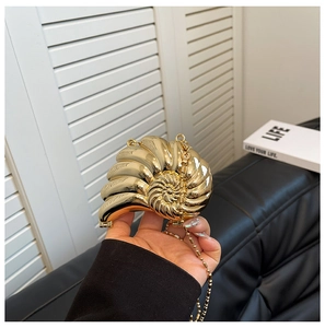 Detailansicht der schneckenförmigen Abendtasche in Goldoptik mit eleganter Kette
