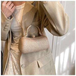 Detail of glitter gold evening clutch with round metal handle and diamond ball clasp