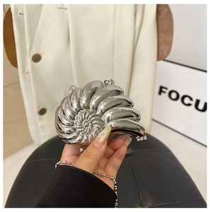 Detailansicht der silbernen Schneckenhaus-Handtasche mit Metallic-Finish und Ringen