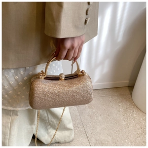 Detail of champagne gold sequin evening clutch with metal handle and diamond clasp