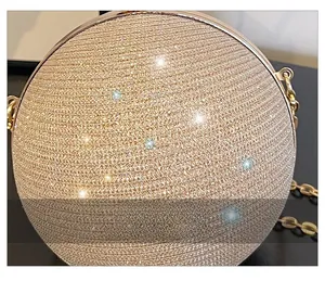 Détail de la surface pailletée et de la chaîne dorée du sac de soirée sphérique
