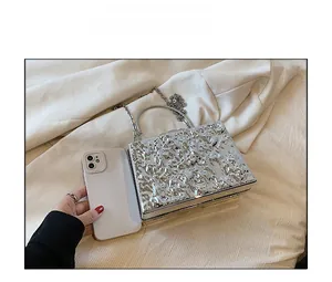 Detailed comparison of silver metal clutch bag with hammered texture and smartphone for scale