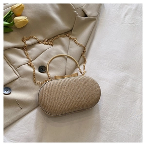 Detail of gold glitter evening clutch bag with metal handle and bow clasp on blazer background